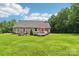 Spacious backyard featuring a deck, lush lawn, fire pit, and beautiful surrounding trees at 320 Bluegill Ln, Statesville, NC 28625