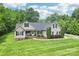 Charming single-story home with manicured lawn, mature trees, and inviting front porch at 320 Bluegill Ln, Statesville, NC 28625