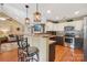 Modern kitchen featuring a breakfast bar, stainless steel appliances, and stylish pendant lighting at 320 Bluegill Ln, Statesville, NC 28625