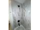 Close-up of the updated marble-tiled shower with modern black shower head and fixtures at 39 E White St, Chester, SC 29706