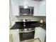 Close-up of stainless steel range and microwave above cooktop in the renovated kitchen space at 39 E White St, Chester, SC 29706