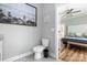 Well-maintained bathroom features stylish commode and vanity with view into the primary bedroom at 3902 Mcgee Point Rd, Terrell, NC 28682