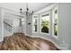 Dining area with large windows, hardwood floors, and a modern chandelier at 3902 Mcgee Point Rd, Terrell, NC 28682