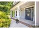 Inviting front porch featuring a blue door, white columns, and a brick-lined base at 3902 Mcgee Point Rd, Terrell, NC 28682
