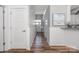 Inviting hallway with wainscoting, hardwood floors, and neutral paint, leading to front door at 3902 Mcgee Point Rd, Terrell, NC 28682