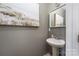 Charming powder room featuring a pedestal sink, stylish mirror, and decorative artwork at 3902 Mcgee Point Rd, Terrell, NC 28682
