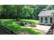 Backyard with a stone fire pit, brick patio, lush green lawn, and mature trees at 4007 Black Oak Rd, Hickory, NC 28602
