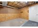 Unfinished basement space featuring pegboard and wood walls with carpet flooring at 4007 Black Oak Rd, Hickory, NC 28602