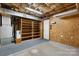 Unfinished basement space featuring shelving units with natural wooden walls and carpet flooring at 4007 Black Oak Rd, Hickory, NC 28602