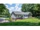 The exterior of the home features a sunroom, fenced yard and lush green lawn at 4007 Black Oak Rd, Hickory, NC 28602