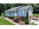 Charming home with light blue siding, a brick chimney, a white porch, and an attached drive-under garage at 4007 Black Oak Rd, Hickory, NC 28602