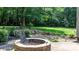 Brick fire pit with cooking grate in a peaceful backyard setting at 4007 Black Oak Rd, Hickory, NC 28602