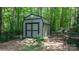 Storage shed with double doors and dark gray siding in a wooded backyard at 4007 Black Oak Rd, Hickory, NC 28602