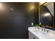 Stylish powder room with a modern vanity, elegant mirror, and sophisticated decor at 4203 Walker Rd, Charlotte, NC 28211