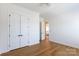 Bright bedroom featuring hardwood floors, closet, and white trim at 4203 Walker Rd, Charlotte, NC 28211