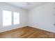 Sunlit bedroom featuring hardwood floors, white trim, and multiple windows at 4203 Walker Rd, Charlotte, NC 28211