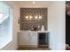Modern wet bar with beverage fridge, custom cabinetry, and patterned backsplash with a window to the side at 4203 Walker Rd, Charlotte, NC 28211
