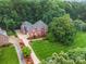 Stunning aerial view of a large brick home, showcasing the manicured lawn and mature trees at 4644 Snow Dr, Harrisburg, NC 28075