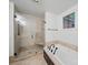 A modern bathroom with stone tile in the shower, glass doors, and soaking tub with black fixtures at 4644 Snow Dr, Harrisburg, NC 28075