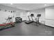 Home gym featuring black rubber floors, free weights, and a treadmill at 4644 Snow Dr, Harrisburg, NC 28075