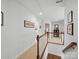 Upstairs hallway with hardwood floors, white walls, and staircase with wooden railings at 4644 Snow Dr, Harrisburg, NC 28075