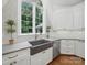 Charming kitchen featuring farmhouse sink, white cabinetry, and natural light at 4644 Snow Dr, Harrisburg, NC 28075