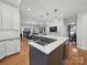 Modern kitchen featuring a large island with gas stove, open floor plan to living room at 4644 Snow Dr, Harrisburg, NC 28075