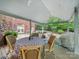 Inviting covered patio with a table, ceiling fans, and views of the wooded yard at 4644 Snow Dr, Harrisburg, NC 28075