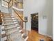 Traditional staircase features hardwood steps with a decorative carpet runner and elegant white railings at 4644 Snow Dr, Harrisburg, NC 28075