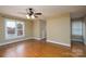 Empty bedroom with hardwood floors, neutral walls, ample natural light from the windows, and ceiling fan at 4672 Snow Dr, Harrisburg, NC 28075
