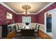Formal dining room with elegant chandelier, decorative wallpaper, and virtual staging at 4672 Snow Dr, Harrisburg, NC 28075