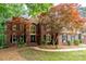 Charming brick home featuring mature trees, manicured lawn, and a welcoming front entrance at 4672 Snow Dr, Harrisburg, NC 28075