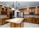 Well-appointed kitchen features a center island, stainless steel appliances, and wood cabinetry at 4672 Snow Dr, Harrisburg, NC 28075