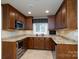 Charming kitchen features granite countertops, a wine cooler, and plenty of wood cabinets for storage at 4672 Snow Dr, Harrisburg, NC 28075