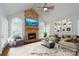 Inviting living room with stone fireplace, arched windows, a ceiling fan, and ample seating at 4672 Snow Dr, Harrisburg, NC 28075