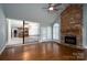 Spacious living room featuring hardwood floors, a stone fireplace, ceiling fan, and access to other rooms at 4672 Snow Dr, Harrisburg, NC 28075