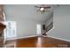 Bright living room with hardwood floors, white trim, a ceiling fan, and a glimpse of the staircase at 4672 Snow Dr, Harrisburg, NC 28075