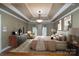 Spacious main bedroom featuring tray ceilings, a modern chandelier and a warm earth-toned palette at 4672 Snow Dr, Harrisburg, NC 28075