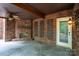 Cozy covered patio featuring a brick fireplace and stylish decor at 4672 Snow Dr, Harrisburg, NC 28075