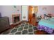 Cozy bedroom featuring a decorative brick fireplace and a beautiful, patterned accent rug on hardwood flooring at 505 S Eastway Dr, Troutman, NC 28166