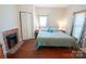Comfortable bedroom showcasing a decorative fireplace, hardwood floors, and bright natural light at 505 S Eastway Dr, Troutman, NC 28166