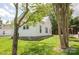 Exterior view of a well-maintained home featuring white siding, a green lawn, and mature trees at 505 S Eastway Dr, Troutman, NC 28166