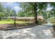 A large tree shades the driveway of this beautiful brick home with an American flag at 5424 Doncaster Dr, Charlotte, NC 28211
