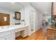 Hallway featuring a vanity, wood floors, and access to other rooms at 5424 Doncaster Dr, Charlotte, NC 28211