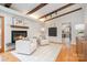 Cozy living room with exposed beams, a brick fireplace, and hardwood flooring at 5424 Doncaster Dr, Charlotte, NC 28211