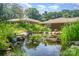 A serene pond is surrounded by lush greenery, adding a peaceful touch to the landscape at 5424 Doncaster Dr, Charlotte, NC 28211