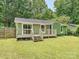 Charming green home featuring a well-maintained backyard with a wooden deck and a privacy fence at 5811 Rock Hollow Dr, Charlotte, NC 28212