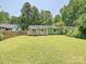 Backyard view of the home, including a deck, siding, and large yard with a wood fence at 5811 Rock Hollow Dr, Charlotte, NC 28212