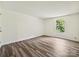 A bright bedroom with wood floors and a window overlooking a green view at 5811 Rock Hollow Dr, Charlotte, NC 28212