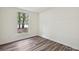 A bright bedroom with wood floors and a window overlooking a green view at 5811 Rock Hollow Dr, Charlotte, NC 28212
